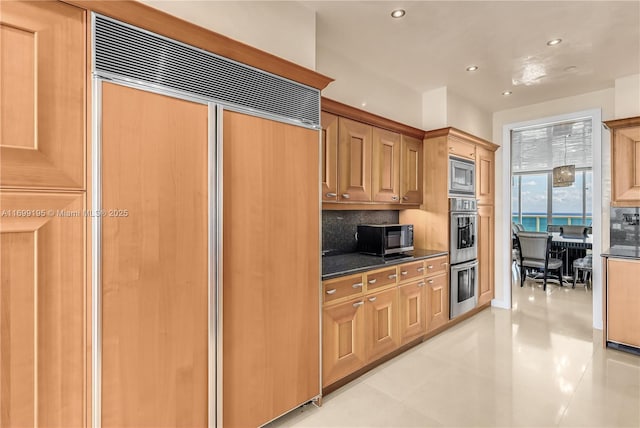 kitchen with backsplash, built in appliances, dark countertops, and recessed lighting