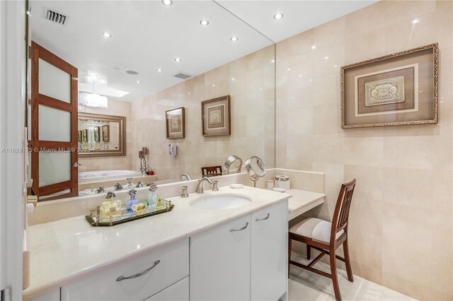 bathroom featuring recessed lighting, visible vents, tile walls, and vanity