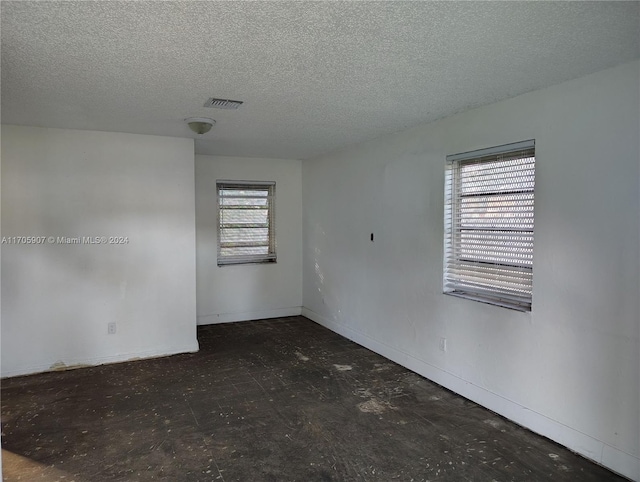 unfurnished room featuring a textured ceiling