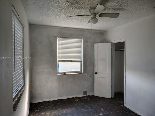 unfurnished bedroom featuring ceiling fan, a closet, and a textured ceiling