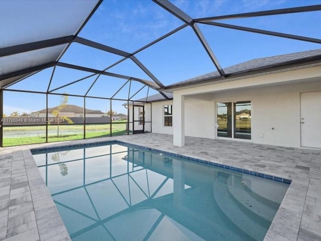 view of pool featuring glass enclosure and a patio