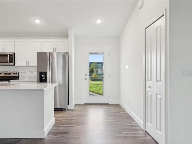 kitchen with white cabinetry, wood-type flooring, and appliances with stainless steel finishes