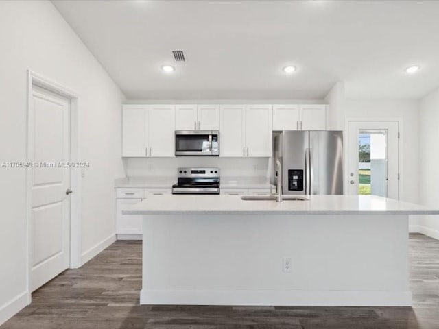 kitchen featuring white cabinetry, sink, dark hardwood / wood-style flooring, a kitchen island with sink, and appliances with stainless steel finishes