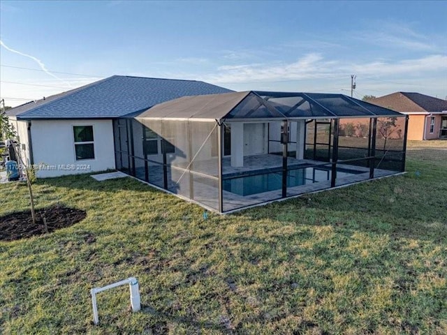 rear view of house with a patio area, a lanai, and a lawn