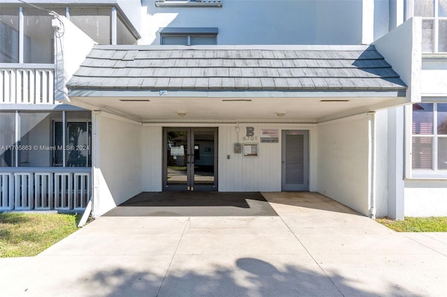 6701 NW 169th St Unit B207, Hialeah, FL 33015 - view of exterior entry with a carport, stucco siding, french doors, and concrete driveway