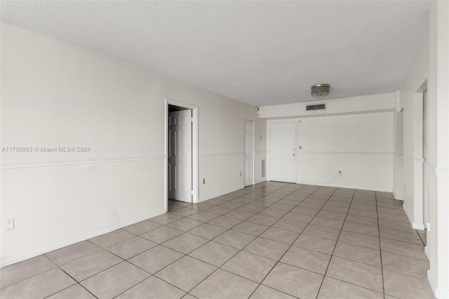 interior space featuring light tile patterned flooring and a textured ceiling