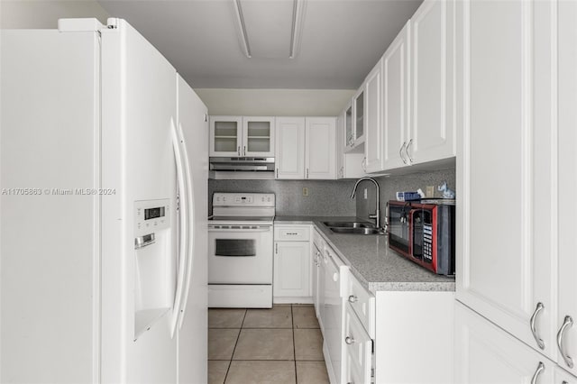 kitchen featuring tasteful backsplash, white appliances, sink, light tile patterned floors, and white cabinets