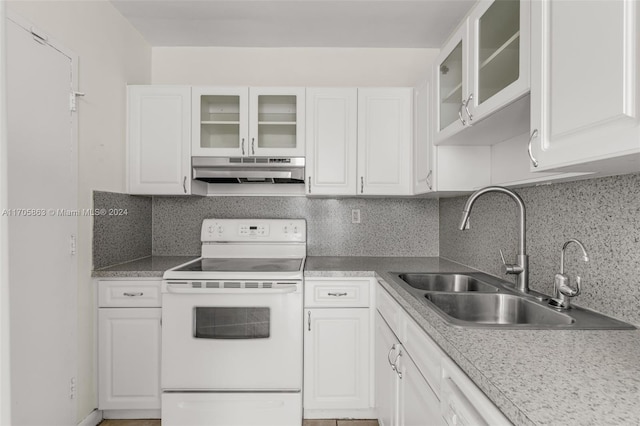 kitchen with white cabinets, decorative backsplash, white range with electric cooktop, and sink