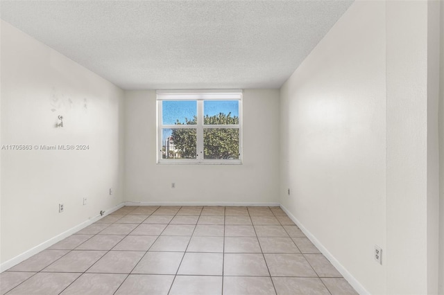 6701 NW 169th St Unit B207, Hialeah, FL 33015 - spare room featuring a textured ceiling and light tile patterned flooring