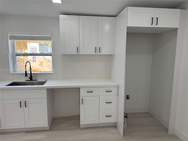 kitchen featuring decorative backsplash, sink, white cabinets, and light wood-type flooring