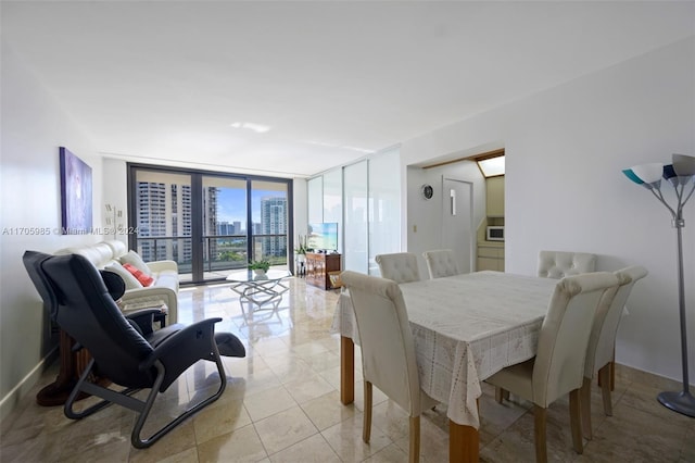 dining room featuring light tile patterned flooring and a wall of windows