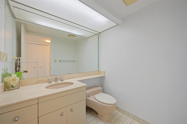 bathroom featuring tile patterned flooring, vanity, and toilet