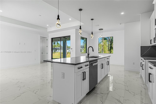 kitchen with dishwasher, sink, white cabinets, and an island with sink