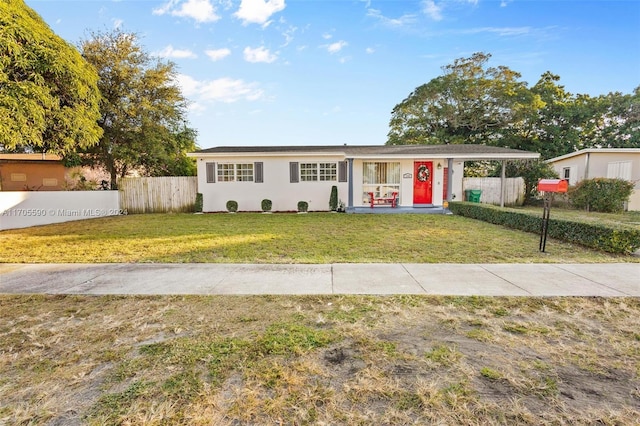 ranch-style house with a front yard and covered porch