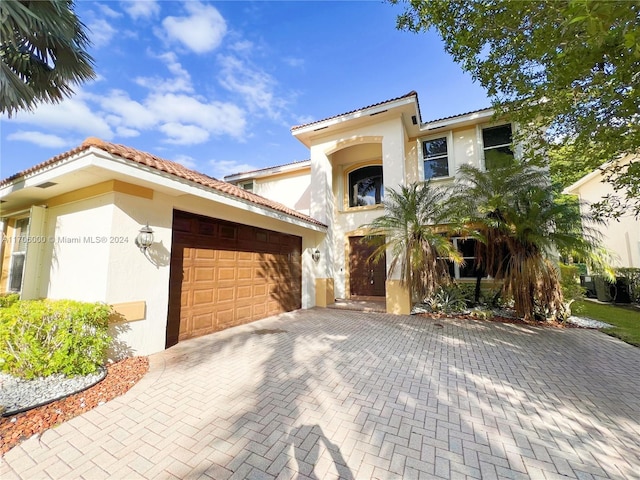 mediterranean / spanish home featuring a garage