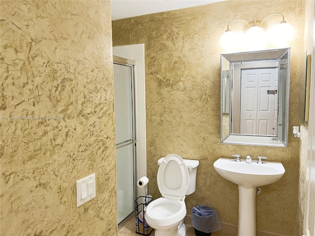 bathroom featuring a shower with shower door and toilet