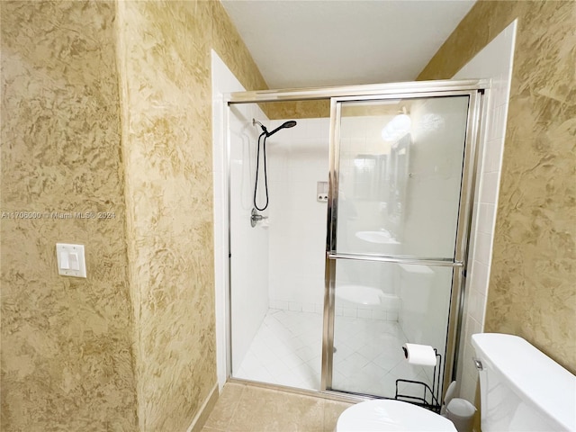 bathroom with tile patterned floors, an enclosed shower, and toilet