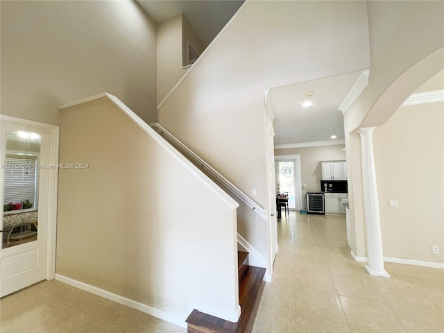 stairs with a high ceiling, tile patterned floors, and ornamental molding