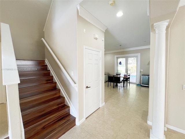 staircase with decorative columns and ornamental molding