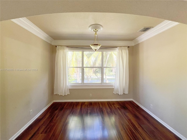 spare room with dark hardwood / wood-style flooring and crown molding