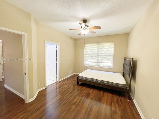 bedroom featuring a textured ceiling, ceiling fan, and dark wood-type flooring