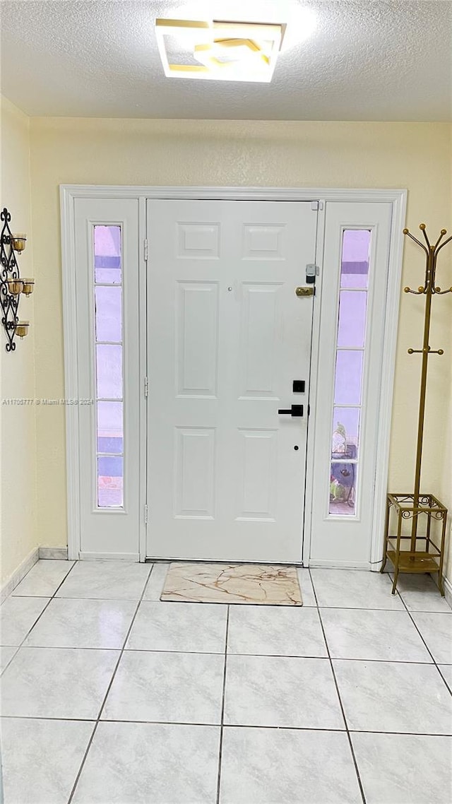 tiled entrance foyer featuring plenty of natural light and a textured ceiling