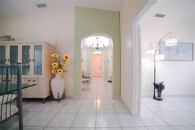 hallway featuring light tile patterned floors and vaulted ceiling