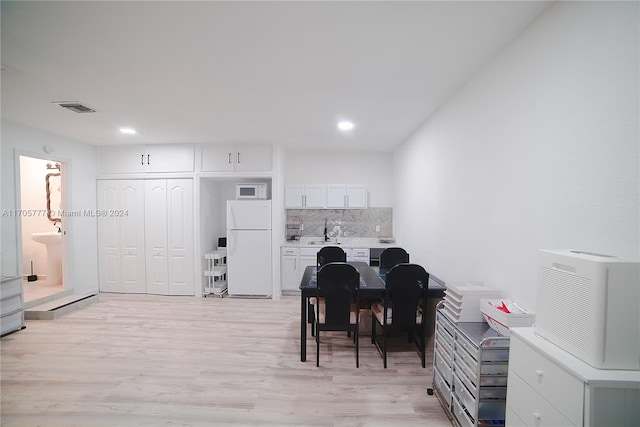 dining room with sink and light wood-type flooring