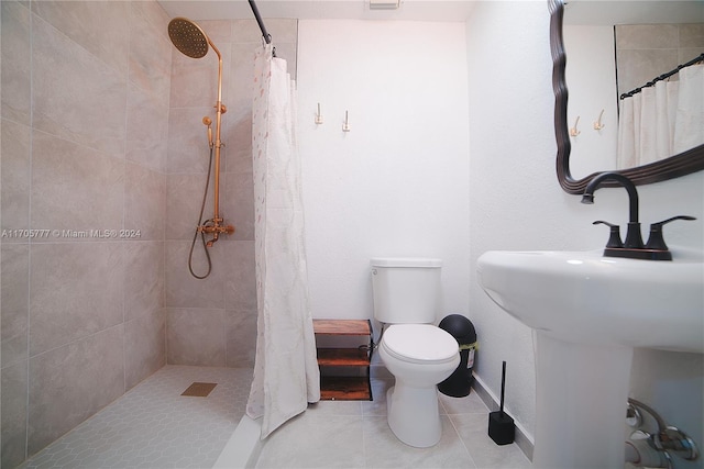 bathroom with a shower with curtain, tile patterned flooring, and toilet