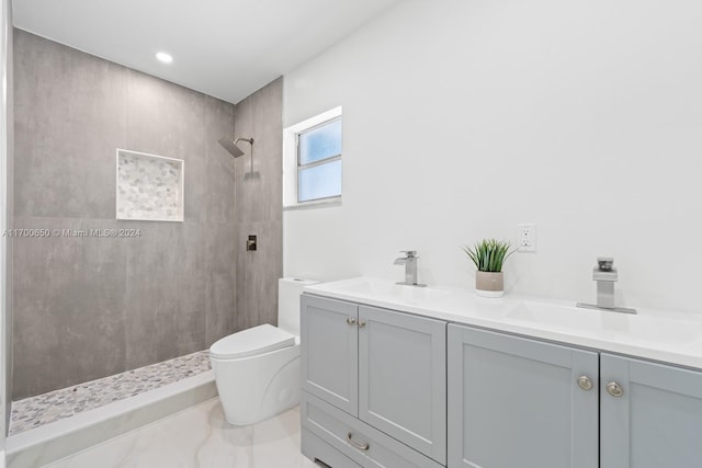 bathroom featuring vanity, toilet, and tiled shower