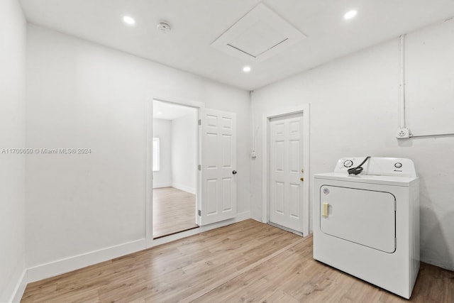 washroom with washer / dryer and light hardwood / wood-style flooring