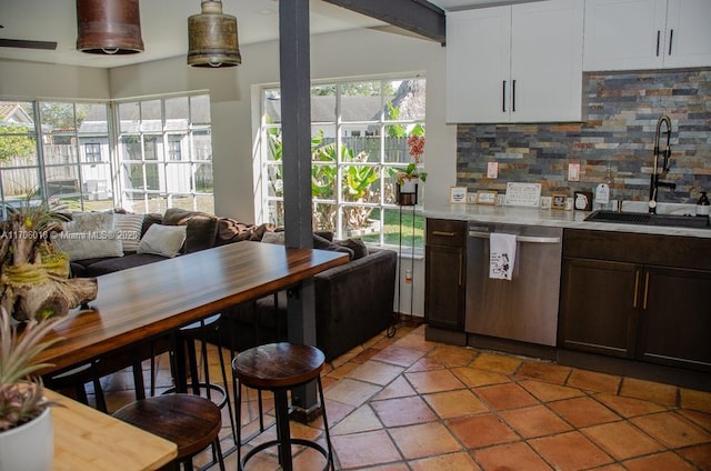 kitchen with sink, dishwasher, white cabinetry, a wealth of natural light, and decorative backsplash