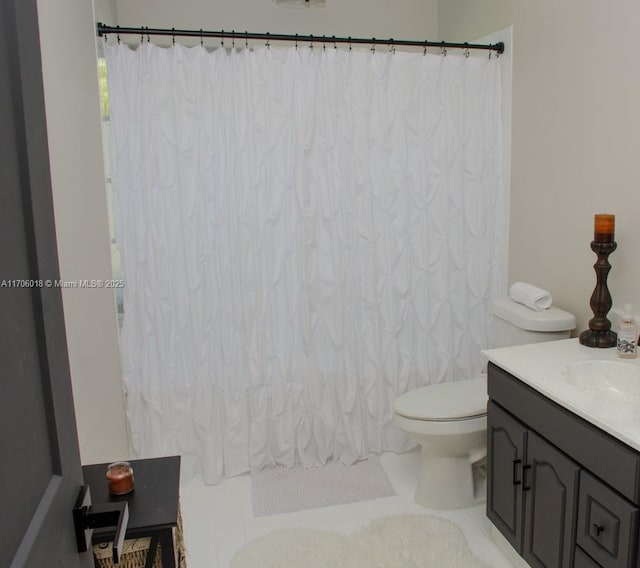 bathroom featuring vanity, tile patterned flooring, and toilet