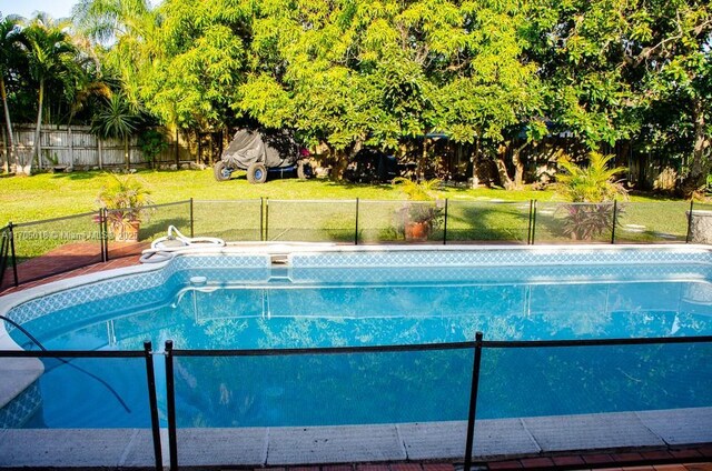 view of pool featuring a lawn