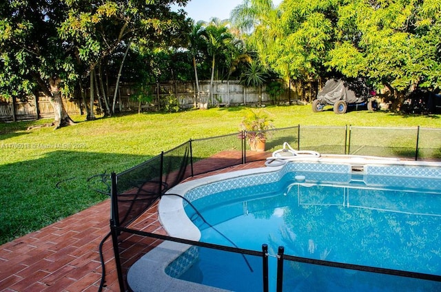 view of swimming pool featuring a yard