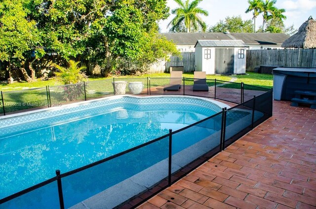 view of swimming pool with a storage shed, a yard, and a patio area