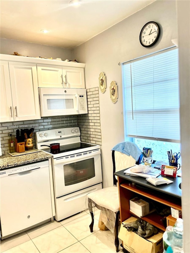 kitchen with tasteful backsplash, white cabinetry, light tile patterned floors, and white appliances