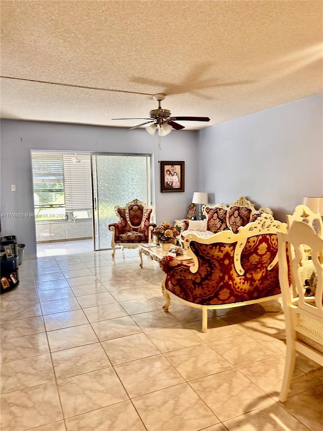 living room featuring tile patterned floors, ceiling fan, and a textured ceiling