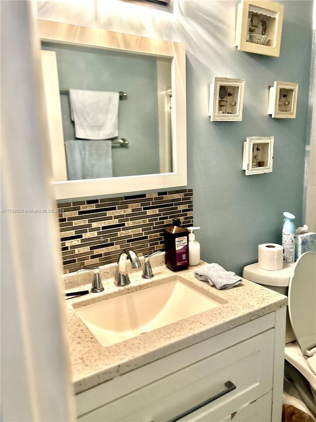 bathroom featuring backsplash, vanity, and toilet