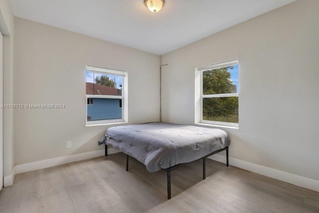 bedroom featuring multiple windows and light wood-type flooring