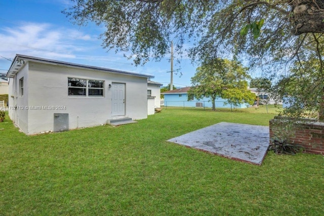 back of house featuring a patio and a lawn