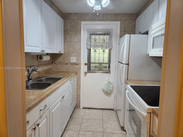 kitchen with a textured ceiling, white cabinetry, sink, and white appliances