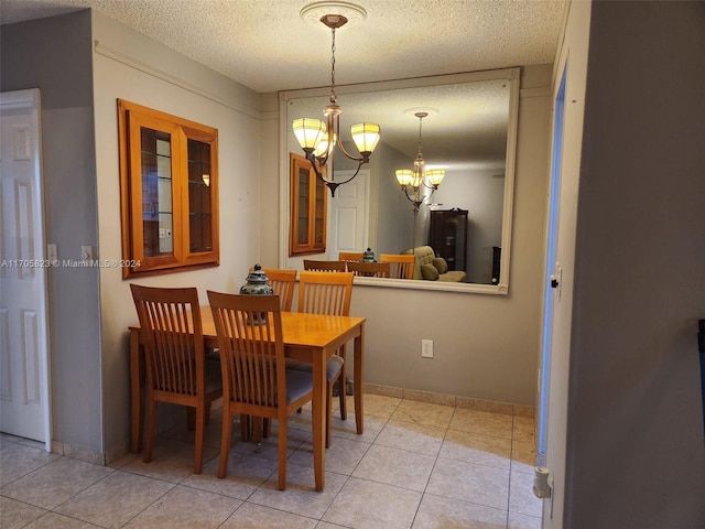 dining area featuring light tile patterned flooring, a textured ceiling, and a notable chandelier