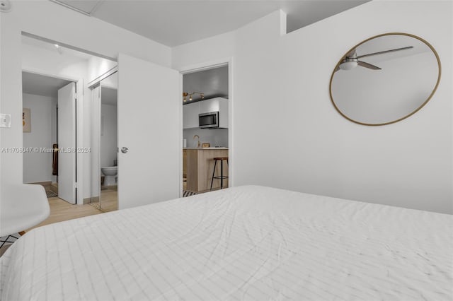 bedroom featuring ensuite bathroom, light hardwood / wood-style flooring, and ceiling fan