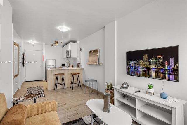 living room with sink and light hardwood / wood-style flooring