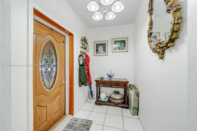 tiled foyer entrance with a chandelier