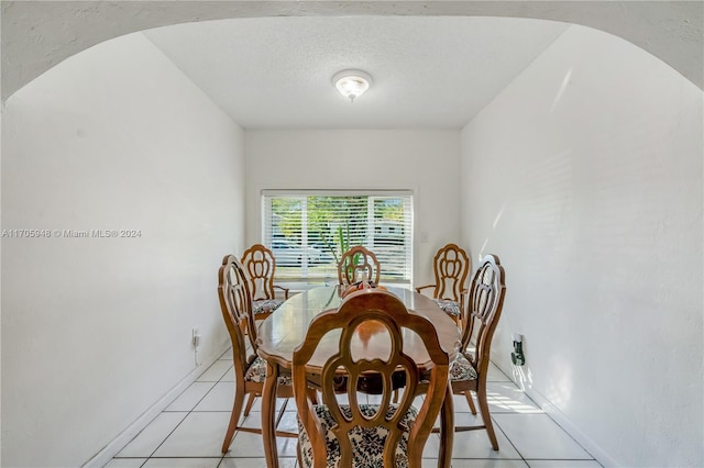 dining room with light tile patterned flooring and a textured ceiling