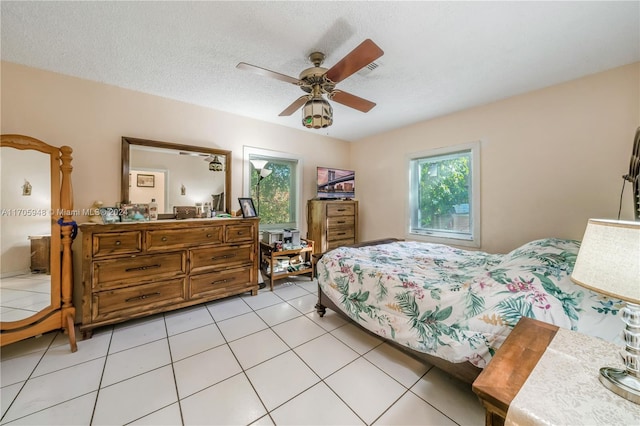 bedroom featuring light tile patterned floors, a textured ceiling, and ceiling fan