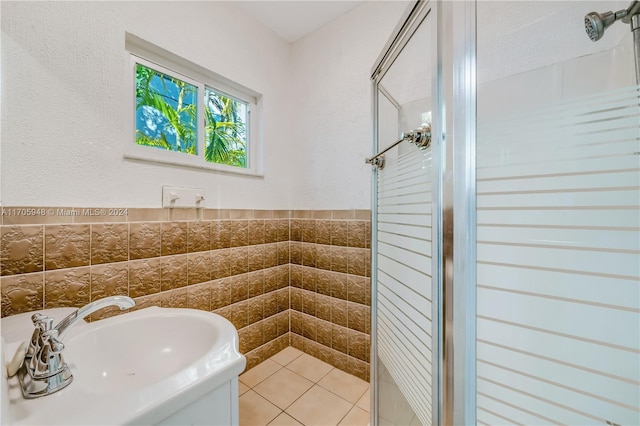 bathroom featuring tiled shower, sink, and tile walls