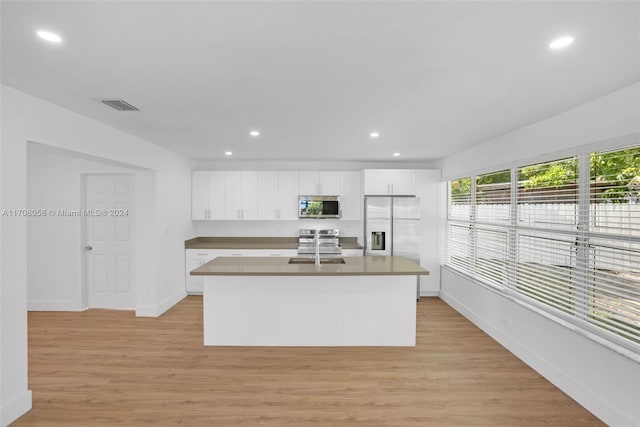 kitchen with white cabinetry, light wood-type flooring, a kitchen island with sink, and appliances with stainless steel finishes